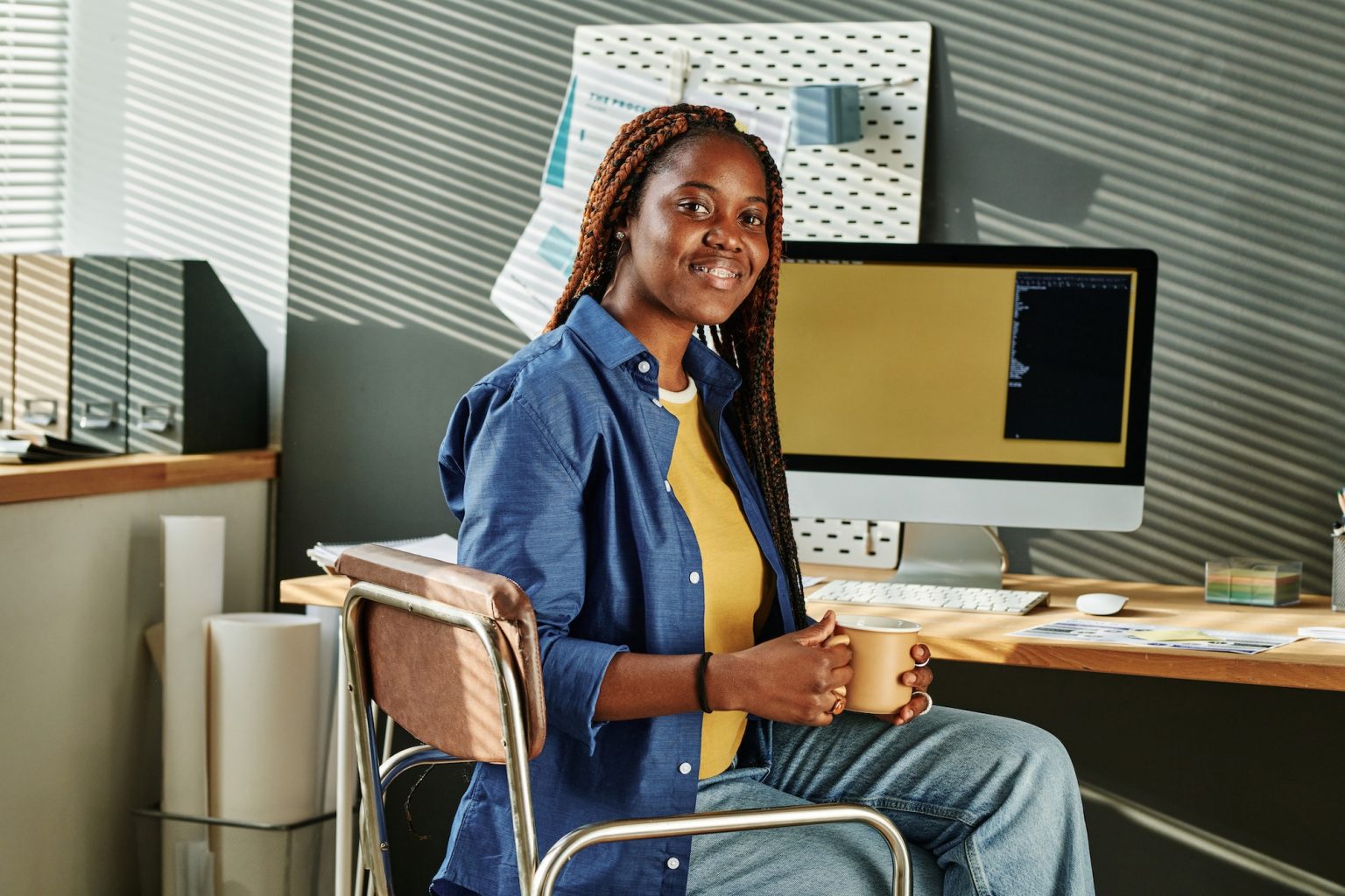 happy-young-african-american-female-intern-with-cup-of-coffee